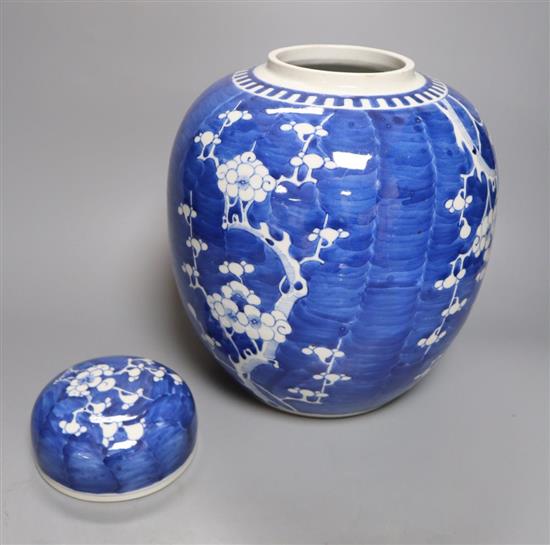 A pair of large Chinese blue and white prunus jars and covers, early 20th century, wood stands, 43cm total height